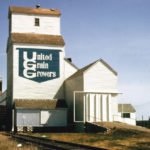 In 1927, United Grain Growers built a 30,000-bushel elevator at Pipestone to replace an earlier elevator dating from 1897. A 30,000-bushel balloon annex was constructed on its east side in 1952. Renovated between 1967 and 1968, it became the second UGG elevator here when, in early 1979, the company traded for the Manitoba Pool elevator (built 1929) in the background of this 1971 photo. Both elevators were closed in October 1991 and demolished in March 1992.