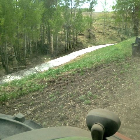 A farmer seeding east of Olds, Alta. on May 23 snapped a photo from the cab showing what was described as a last ribbon of snow at the field’s edge. Central and northern Alberta are expected to have a drier bias heading into August and September. (Submitted photo)
