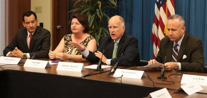 California Governor Jerry Brown (shown here Tuesday, third from right, with state lawmakers) has signed legislation to put a water bond to voters in November. (Justin Short photo, Gov.Ca.gov)
