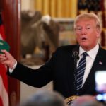 U.S. President Donald Trump holds up a cap reading “Make Our Farmers Great Again” while delivering remarks at a showcase of U.S.-made products at the White House in Washington on July 23, 2018. (Photo: Reuters/Carlos Barria)
