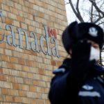 A police officer gestures at the photographer outside Canada’s embassy in Beijing on Dec. 12, 2018. (Photo: Reuters/Thomas Peter)
