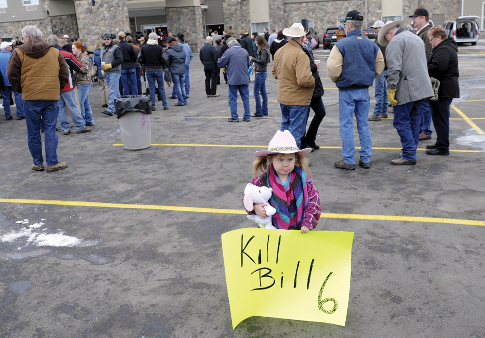 A three-year-old holds a protest sign ahead of a Dec. 2, 2015 meeting at Okotoks, Alta. between farmers and ranchers and Alberta’s then-ministers of labour and agriculture. (Photo: Reuters/Mike Sturk)
