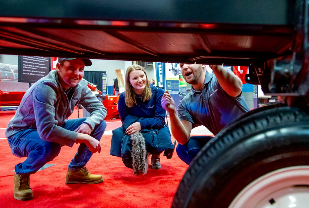 Rhett Dodds and Siobhan Jackson get the rundown on the MacDon Flexdraper FD135 header from Andrew Gossart of Winnipeg.