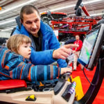 Andriy Kovalemko of Brandon helps his 3 1/2 year old son, also Andriy, navigate a driver operating system simulator.