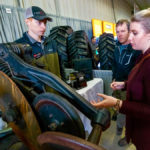 Matt Faul of Fargo's Gen Ag Parts listens to a question from Nicole Dow of Portage while her dad Kelly Ronald looks on.
