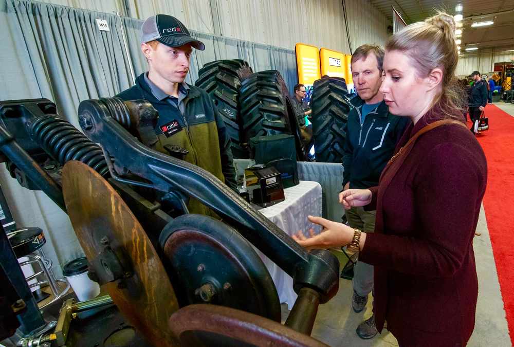 Matt Faul of Fargo's Gen Ag Parts listens to a question from Nicole Dow of Portage while her dad Kelly Ronald looks on.