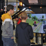 Two youngsters play a farming simulation game in one of the exhibitor halls.