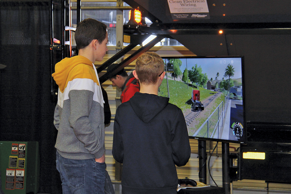 Two youngsters play a farming simulation game in one of the exhibitor halls.