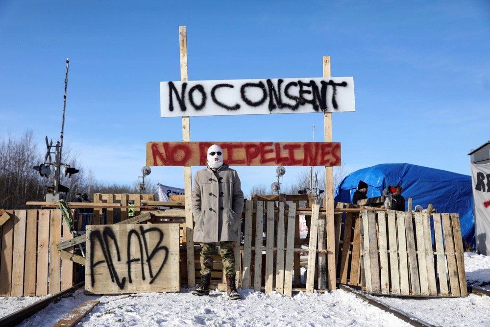 A demonstrator stands at a blockade on CN track west of Edmonton on Feb. 19, 2020. (Photo: Reuters/Codie McLachlan)

