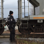 A Metro Vancouver Transit officer watches as a train passes on a westbound track while protesters block eastbound tracks on a CP rail bridge at Port Coquitlam, B.C. on Feb. 13.