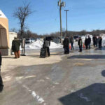 Customers wait in line to get into the St. Norbert Farmers’ Market on March 21, part of safety measures the market enacted.