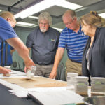 Randy Dennis (l), the former chief grain inspector for Canada, demonstrates the ins and outs of grain grading at a workshop. The Canadian Grain Commission is reviewing the grading system. While some groups want to switch to instrument-measured specifications, others warn that could create problems.