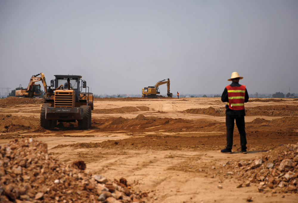 Workers and excavators are seen at a construction site of a new pig farm in Beijing’s eastern Pinggu district.