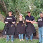 Parker, Val and Darcy Watson accept their award jackets from Ron McDonald of the Manitoba Charolais Association after being named 2020 commercial breeder of the year.