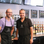 Tyler Kilkenny (left) and Todd Sawyer step behind the coffee bar of their giftware/coffee shop in Russell.