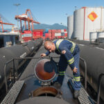 A West Coast Reduction worker inspects a shipment being delivered to their location for export at the Port of Vancouver.
