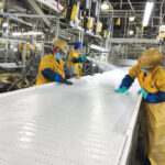 Workers disinfect a conveyor belt, part of the measures installed to help slow the spread of coronavirus disease (COVID-19) at the Seaboard Foods pork-processing plant in Guymon, Oklahoma, May 17, 2020.