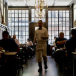 A waiter walks among diners at Peter Luger Steak House in Brooklyn, New York August 12, 2021.