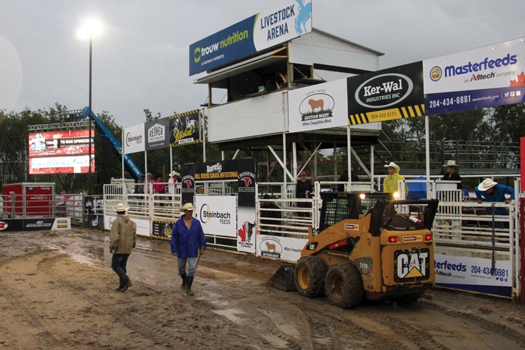 Organizers tried to drain water in front of the chutes before Saturday’s bull riding event.