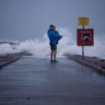 Local resident John Smith holds his 18-month-old son Owen near breaking waves on a pier ahead of the arrival of Tropical Storm Nicholas at Galveston, Texas on Sept. 13.