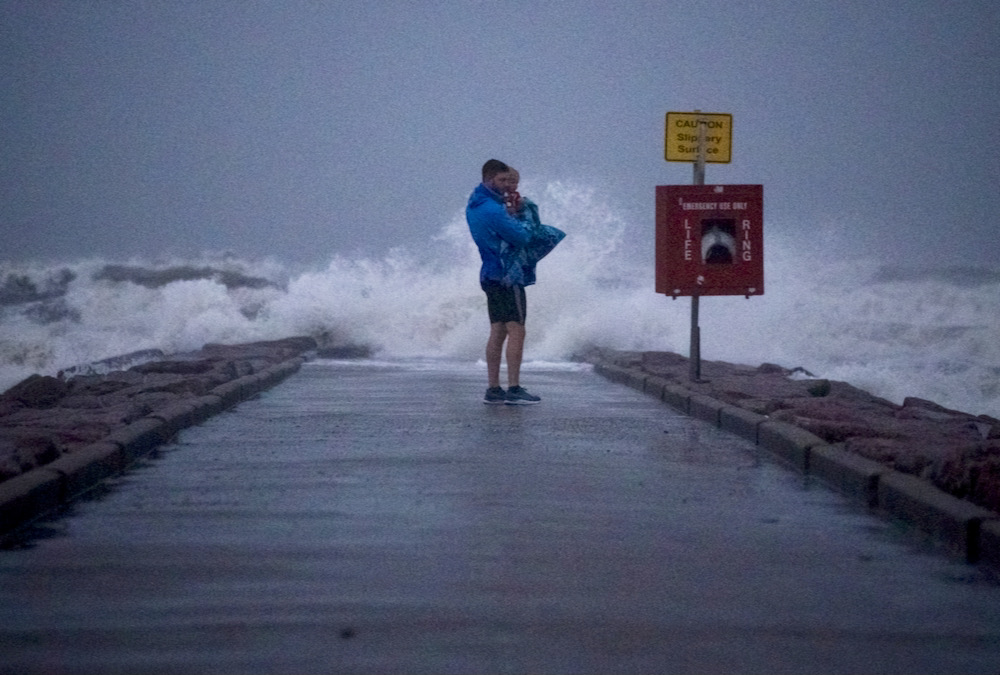 Local resident John Smith holds his 18-month-old son Owen near breaking waves on a pier ahead of the arrival of Tropical Storm Nicholas at Galveston, Texas on Sept. 13.