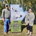 Greg (left) and Brenda (right) Riddell accept the sign marking R4 Ranch as the 2020 Manitoba Charolais Association Commercial Breeder of the Year.
