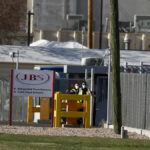 Security wear face masks at the Greeley, Colorado, JBS USA meat packing plant where two staff members had died of COVID-19, April 8, 2020.   Photo: REUTERS/Jim Urquhart/File Photo

