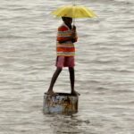A boy stands on a container in a flooded street in Chennai in southern India on Dec. 6, 2010, in the wake of heavy rains believed to be driven by that year’s La Niña event.