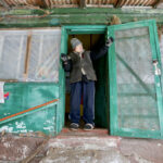 A 77-year-old woman looks out her door in the rebel-controlled area of the Zaitseve settlement in Ukraine’s Donetsk region on Jan. 28. She is among few other people who still live in a village divided by a line of separation between pro-Russian rebels and Ukraine’s armed forces.