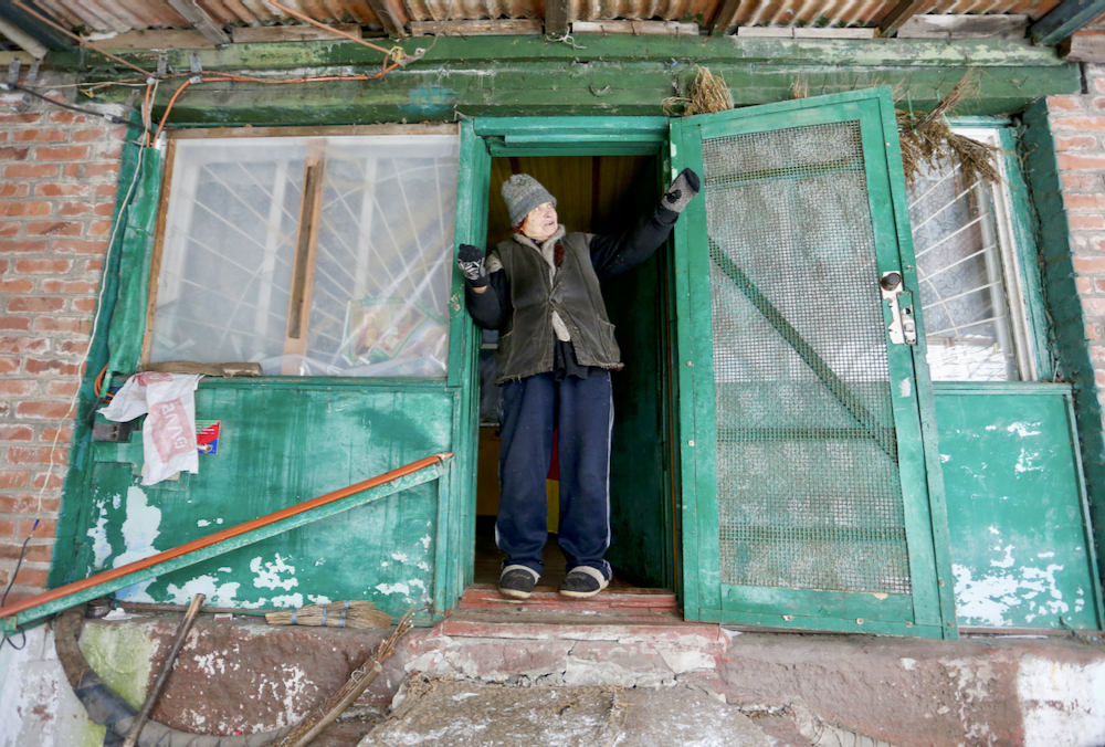 A 77-year-old woman looks out her door in the rebel-controlled area of the Zaitseve settlement in Ukraine’s Donetsk region on Jan. 28. She is among few other people who still live in a village divided by a line of separation between pro-Russian rebels and Ukraine’s armed forces.