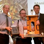Mack Waldner of Baker Community Farm (centre) accepting the award for the 2016 Manitoba Corn Growers Association’s corn yield contest from then MCGA vice- president Leonard Wiebe (l) and association president Myron Krahn (r). Baker won again in 2021 with a yield of 303.3 bushels an acre.