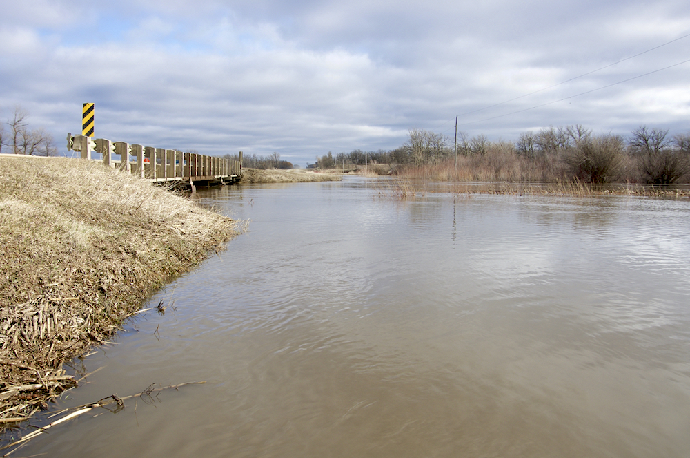 The backed-up Boyne River rushes just below bridge capacity north of Roseisle May 2.