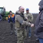 A soldier meets with Ukrainian farmers in the liberated fields of northern Ukraine.