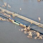 Rail cars weigh down a railway bridge south of St. Jean.