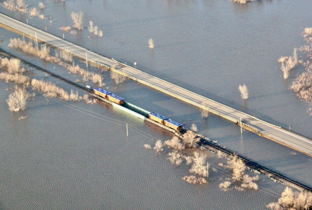 Rail cars weigh down a railway bridge south of St. Jean.