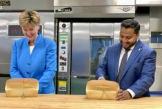 Agriculture and Agri-Food Minister Marie-Claude Bibeau and Cereals Canada CEO Dean Dias forego the customary ribbon cutting for a bread cutting ceremony to celebrate 50 years of Cereals Canada.