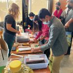 Attendees of the Discover the Farm event crushing canola to create oil.