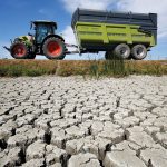 A farmer drives his tractor near cracked and dry earth at the Marais Breton in Villeneuve-en-Retz, as a historic drought hit France in August.