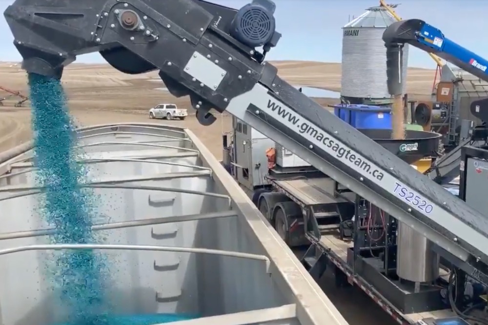 A G-Mac’s custom seed treatment unit loads a truck with treated peas in a 2020 video screengrab. (G-Mac’s AgTeam via YouTube)
