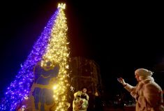 A woman sings a carol in front of a Christmas tree, amid Russia’s attack on Ukraine, at the Sofiyska Square in Kyiv, Ukraine, Dec. 19.
