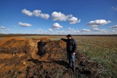 Grain farmer Oleksandr Klepach points at trenches in his field, amid Russia’s invasion of Ukraine, in Snihurivka, southeast Ukraine.