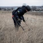 A sapper of the State Emergency Service inspects an area for mines and unexploded shells in Ukraine's Kharkiv region on March 21, 2023.