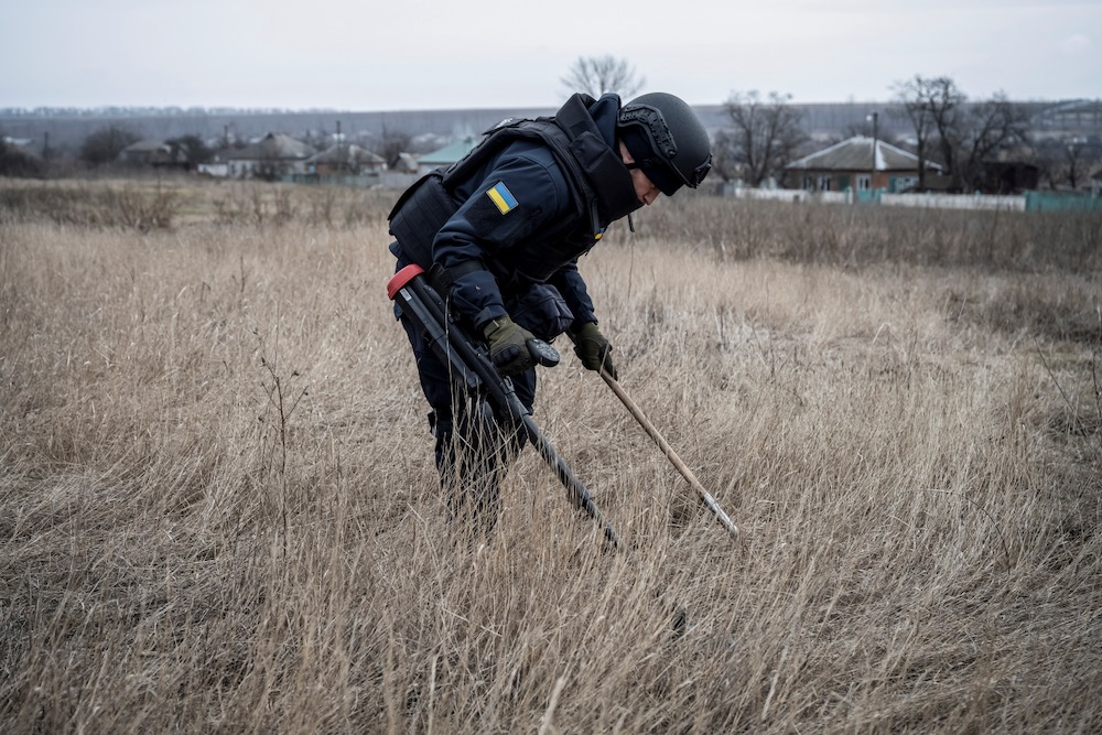 A sapper of the State Emergency Service inspects an area for mines and unexploded shells in Ukraine's Kharkiv region on March 21, 2023.