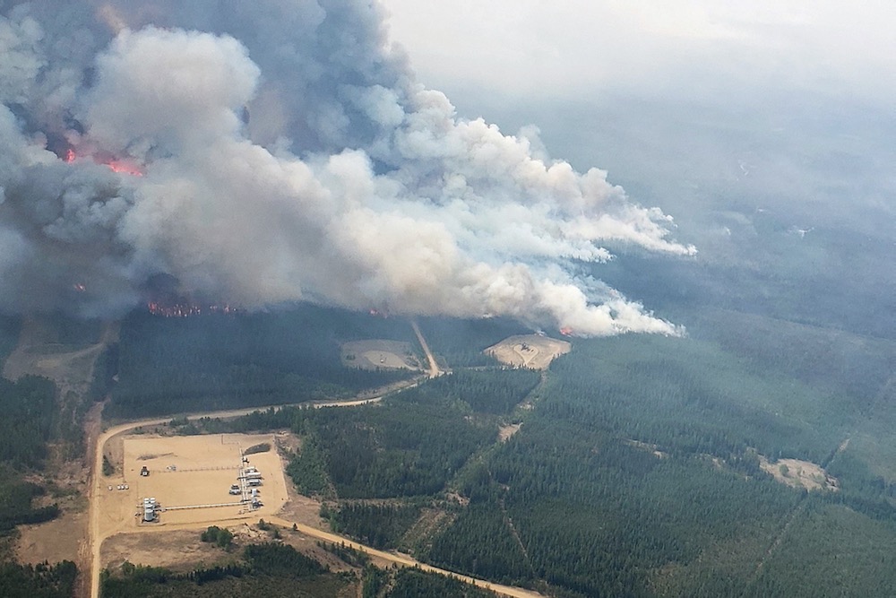 Smoke rises from the southeast side of a wildfire being tackled by helicopters near Shining Bank, Alta., about 200 km west of Edmonton, on May 19, 2023. (Photo: Alberta Wildfire/Handout via Reuters)
