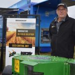 Neale Heinrich stands in front of the Redekop Seed Control Unit at its booth at Ag in Motion on July 18, 2023. (Braedyn Wozniak photo)