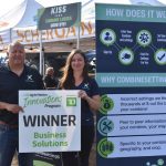 Trevor Scherman and Megan Madden hold the sign displayed in front of their ScherGain booth at Ag in Motion on July 20, 2023.  Photo: Braedyn Wozniak
