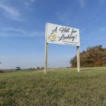 A sign referencing local author Martha Paine Brooks welcomes visitors to the viewpoint at Ninette, Man.