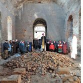 A service in the interior of the damaged church. Local farmers are helping in its restoration.