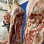 Chair Andy Cardy stands with the winning pork carcass sides at a competition held during the recent Brandon Hog and Livestock Show.