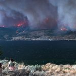 A thick layer of smoke emanates from forest fires on the west side of Okanagan Lake.